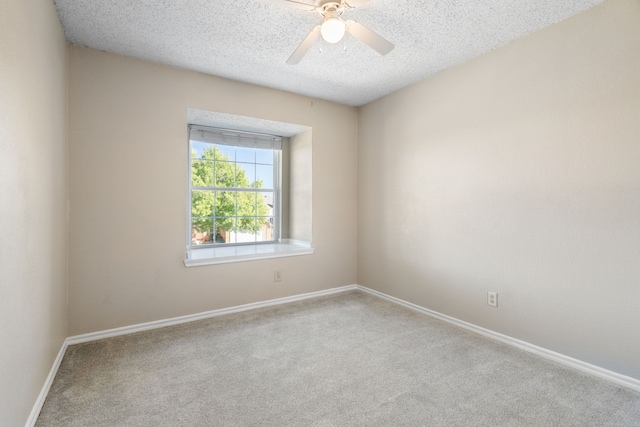 spare room with ceiling fan, light colored carpet, and a textured ceiling