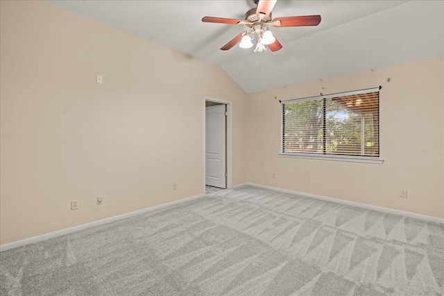 carpeted spare room featuring ceiling fan and vaulted ceiling