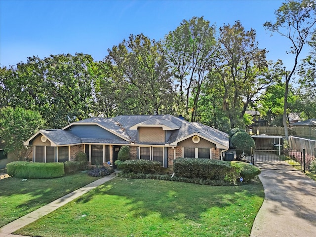 single story home featuring a front yard and a sunroom