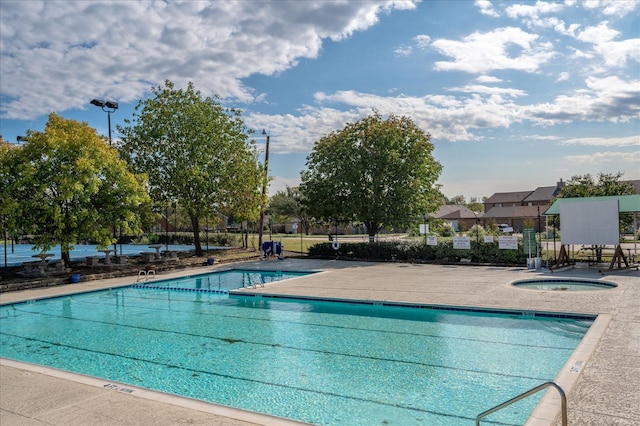 view of swimming pool featuring a hot tub