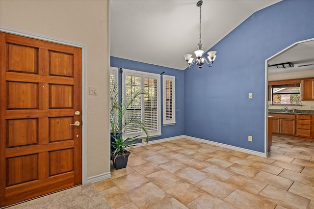 entryway featuring a chandelier, lofted ceiling, sink, and plenty of natural light