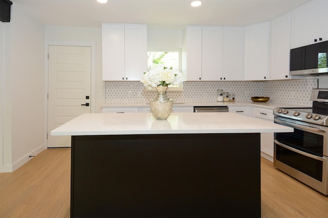 kitchen featuring a kitchen island, white cabinets, light wood-type flooring, and appliances with stainless steel finishes