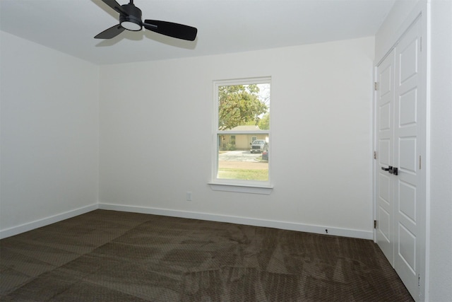 carpeted spare room featuring ceiling fan