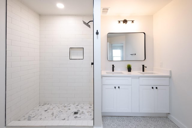 bathroom featuring tiled shower, tile patterned flooring, and vanity