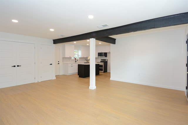 basement featuring sink and light wood-type flooring