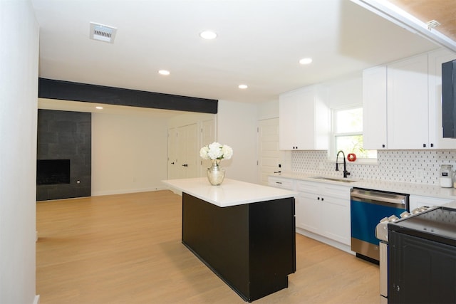 kitchen featuring sink, white cabinetry, a kitchen island, light hardwood / wood-style floors, and stainless steel appliances