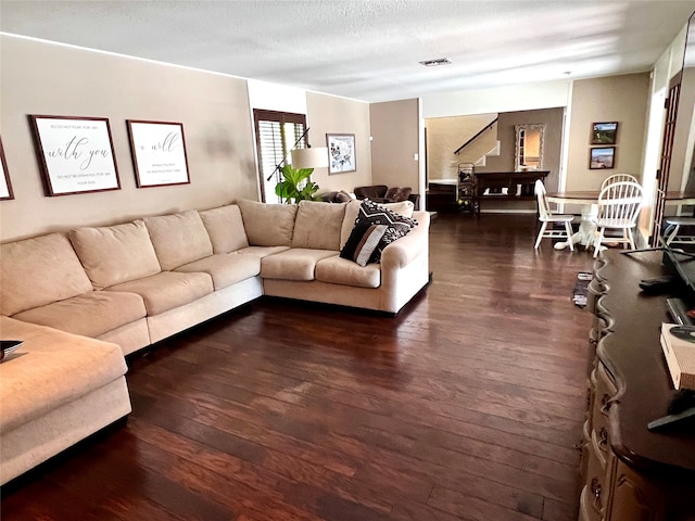 living room with dark wood-type flooring and a textured ceiling