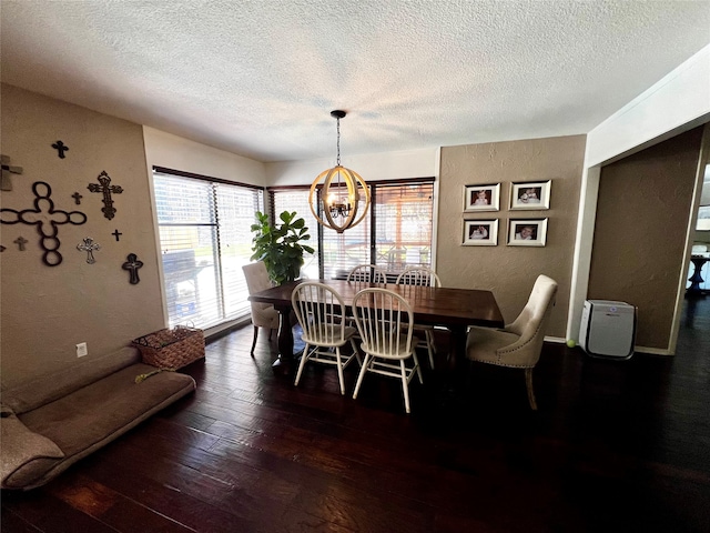 dining room with dark wood-type flooring, a textured ceiling, and an inviting chandelier