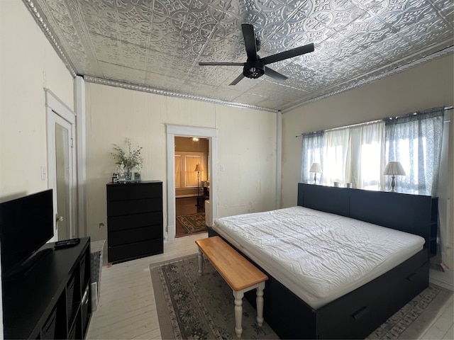 bedroom with ensuite bath, ceiling fan, and light hardwood / wood-style flooring