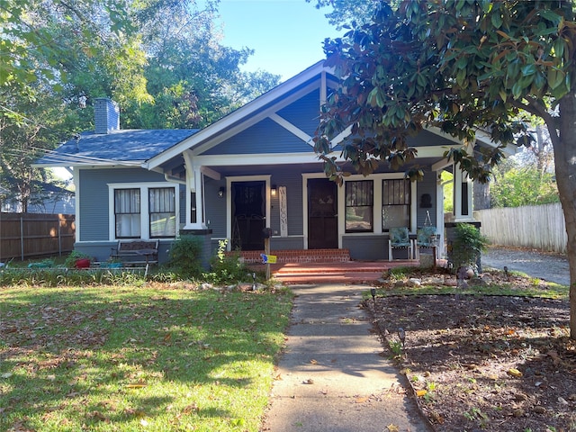 view of front of home featuring covered porch and a front lawn