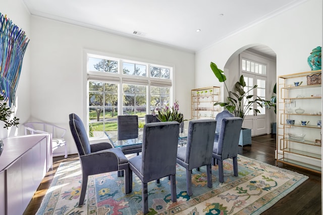 dining space with dark hardwood / wood-style flooring and crown molding