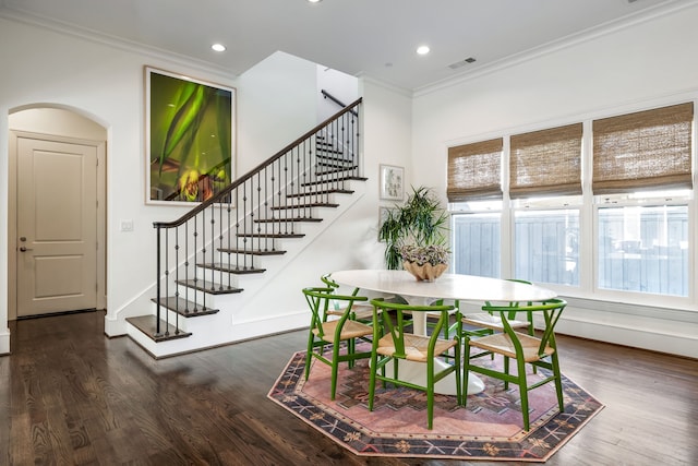 dining space featuring dark wood-type flooring and crown molding