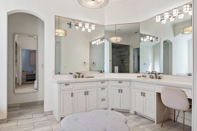 bathroom with walk in shower, vanity, and ornamental molding