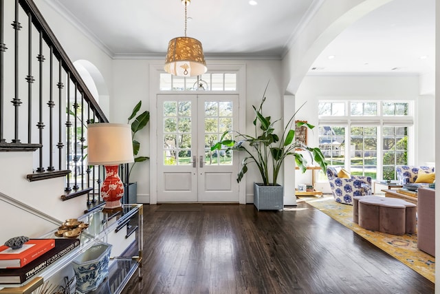 foyer with french doors, dark hardwood / wood-style floors, and crown molding