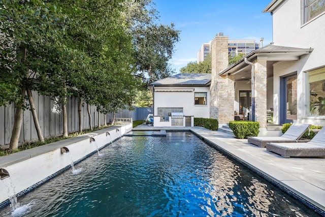 view of swimming pool with pool water feature and a patio area