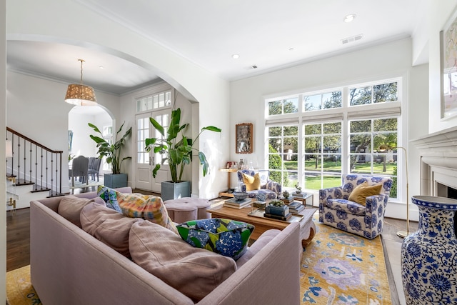 living room featuring wood-type flooring and crown molding