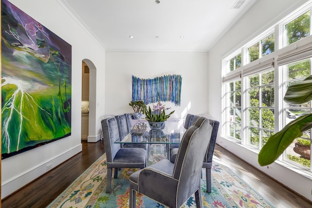 dining room featuring a healthy amount of sunlight, dark hardwood / wood-style flooring, and ornamental molding