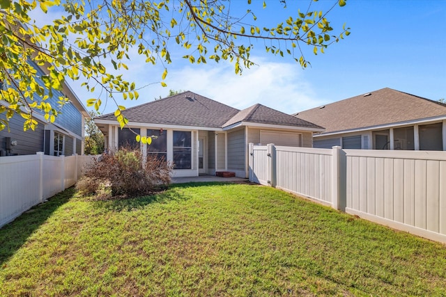 back of property featuring a sunroom and a yard