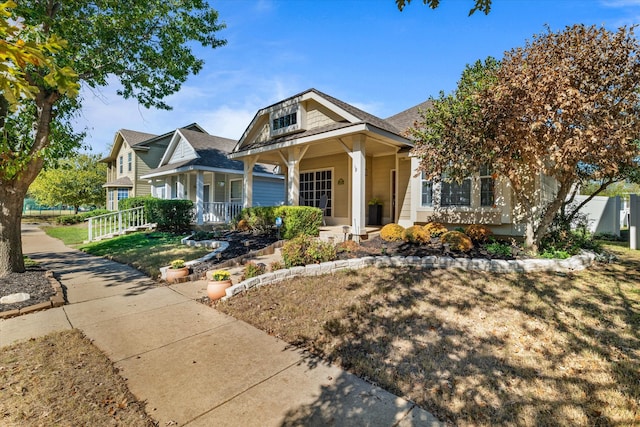 bungalow-style house featuring a front lawn and covered porch