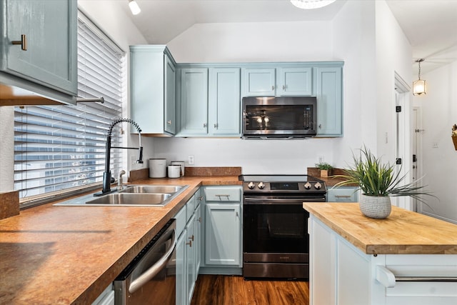 kitchen featuring stainless steel appliances, wood counters, dark hardwood / wood-style flooring, sink, and vaulted ceiling