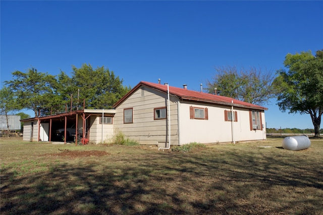 back of property with an outbuilding and a lawn