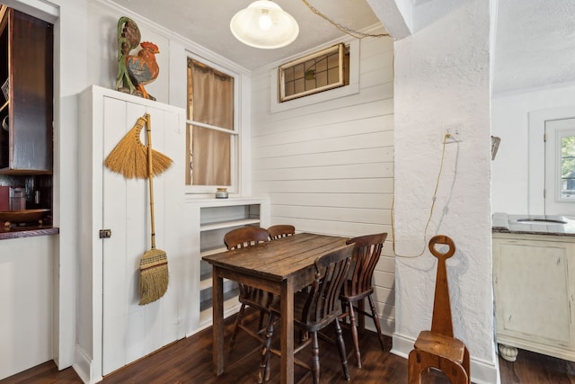 dining area with ornamental molding and dark hardwood / wood-style flooring