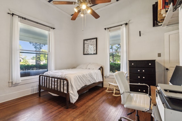 bedroom with ornamental molding, dark hardwood / wood-style flooring, and ceiling fan