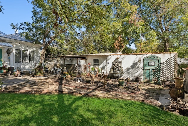 rear view of house featuring a patio and a yard