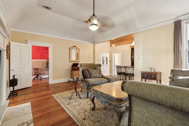 living room with hardwood / wood-style flooring, ceiling fan, lofted ceiling, and ornamental molding