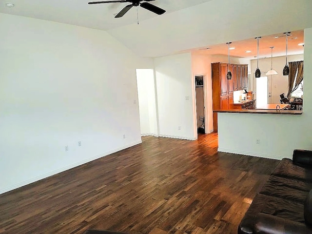 unfurnished living room with dark wood-type flooring, vaulted ceiling, and ceiling fan