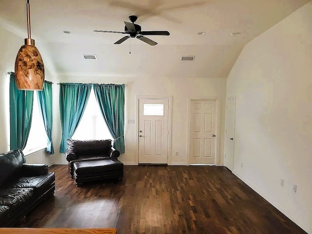 living area featuring dark wood-type flooring, ceiling fan, and vaulted ceiling