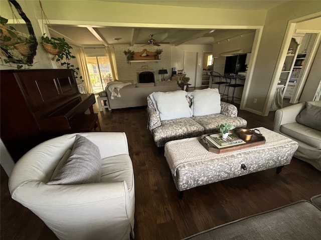 living room with a fireplace, ceiling fan, beam ceiling, and dark hardwood / wood-style flooring