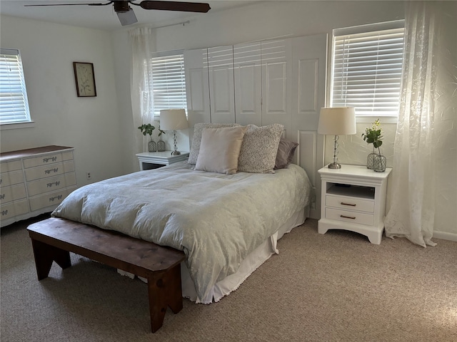 bedroom featuring a closet, light colored carpet, and ceiling fan