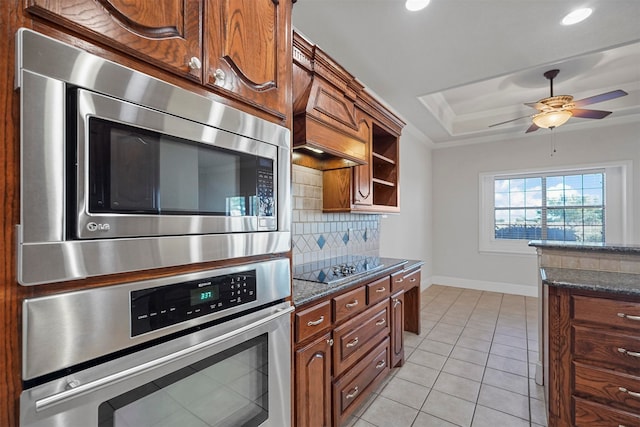 kitchen featuring dark stone countertops, backsplash, light tile patterned floors, and stainless steel appliances