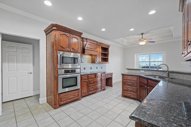 kitchen featuring stainless steel appliances, sink, ceiling fan, light tile patterned floors, and a tray ceiling