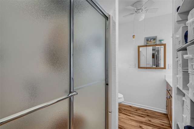 bathroom with a shower with door, vanity, hardwood / wood-style flooring, and ceiling fan