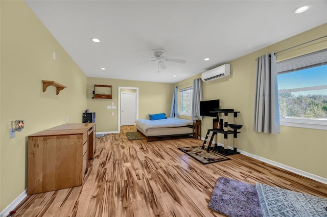 bedroom featuring an AC wall unit, ceiling fan, and light hardwood / wood-style flooring