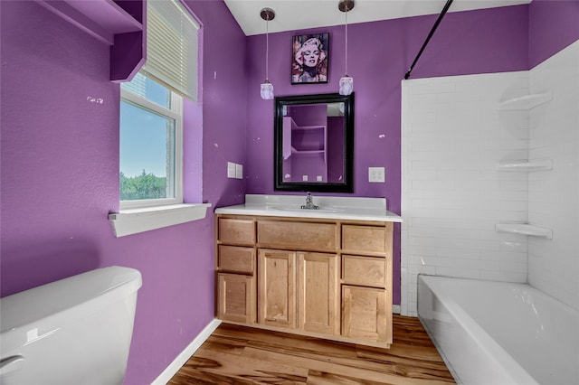 full bathroom featuring hardwood / wood-style flooring, vanity, toilet, and tiled shower / bath combo