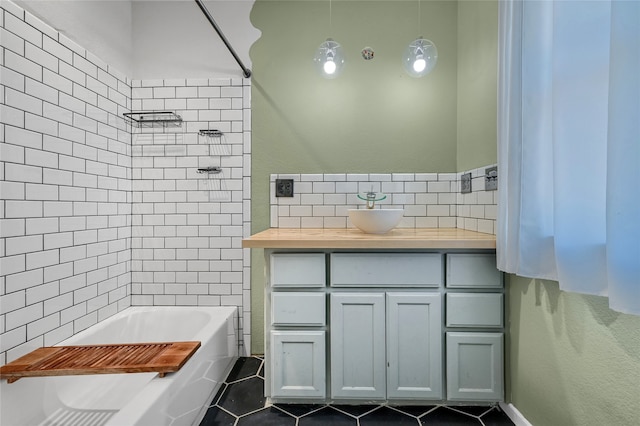 bathroom featuring tile patterned flooring, vanity, and tiled shower / bath