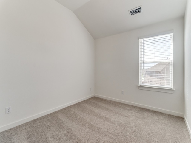 carpeted spare room with lofted ceiling