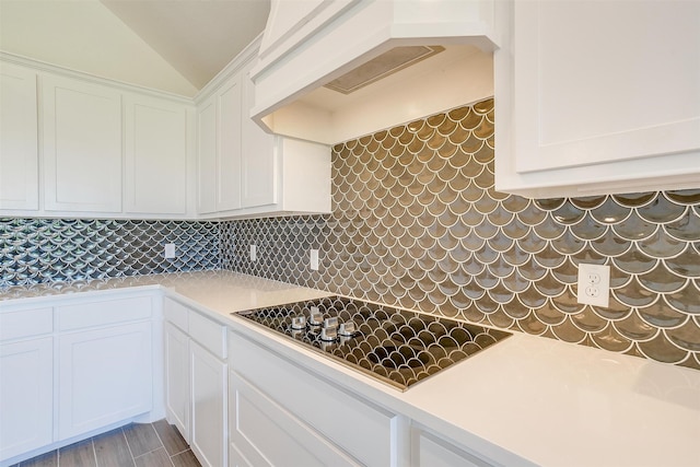 kitchen with black electric cooktop, white cabinetry, decorative backsplash, and wood-type flooring