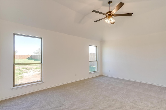 spare room featuring vaulted ceiling, light carpet, and ceiling fan