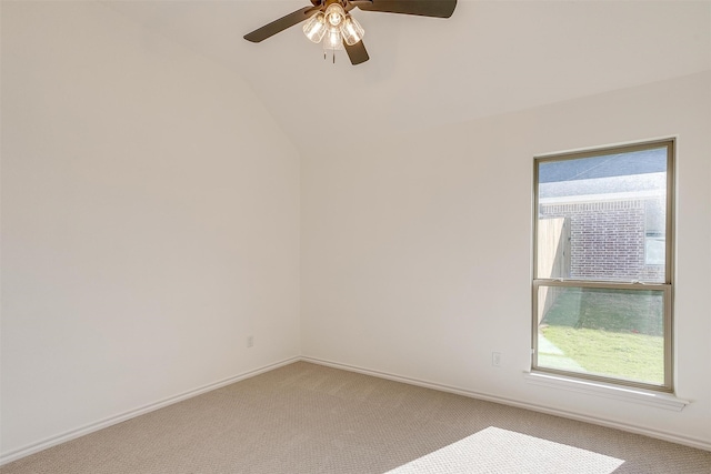 carpeted spare room with vaulted ceiling, ceiling fan, and plenty of natural light