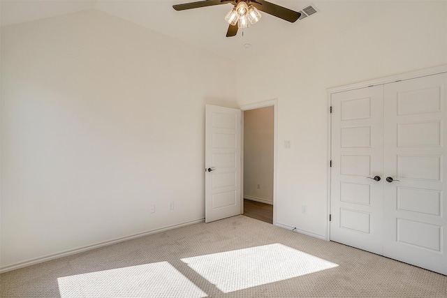 unfurnished bedroom with light carpet, ceiling fan, lofted ceiling, and a closet