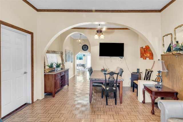 dining area featuring light parquet floors, crown molding, and a notable chandelier