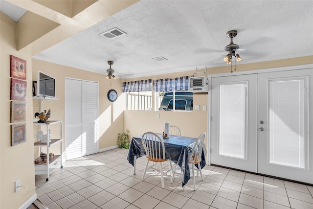 tiled dining room with ceiling fan, a textured ceiling, and french doors