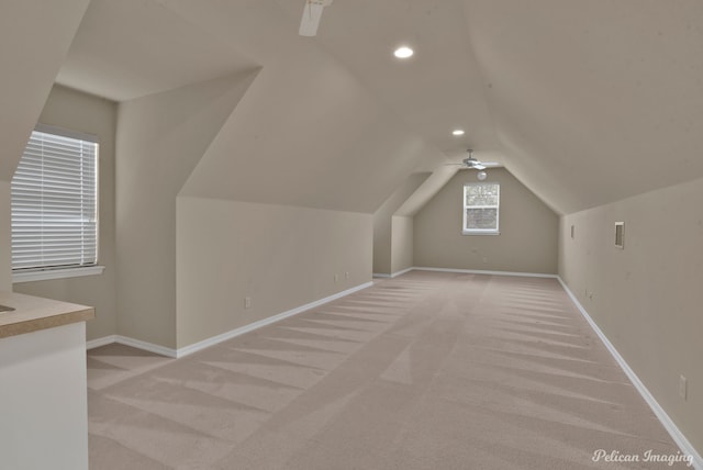 additional living space with lofted ceiling, light colored carpet, and ceiling fan