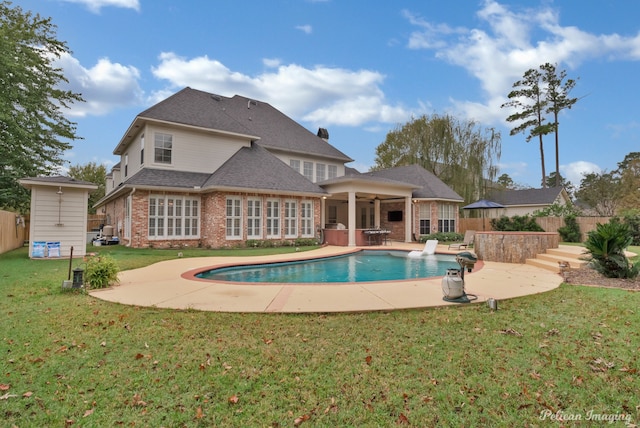 rear view of property featuring a fenced in pool, a patio, and a lawn