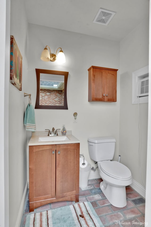 bathroom with vanity, toilet, and a wall mounted air conditioner