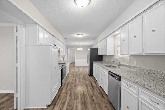 kitchen featuring white cabinetry, appliances with stainless steel finishes, light stone counters, and dark hardwood / wood-style flooring